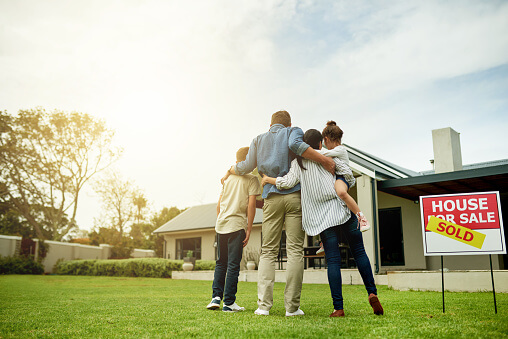 Image of family out side of their new home